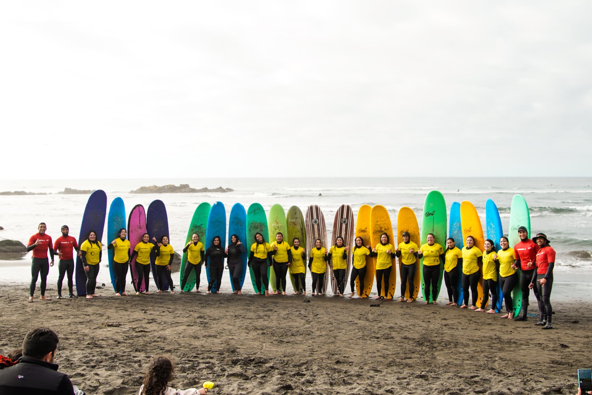 Grupo de jiu-jiteras con tablas de surf en la playa